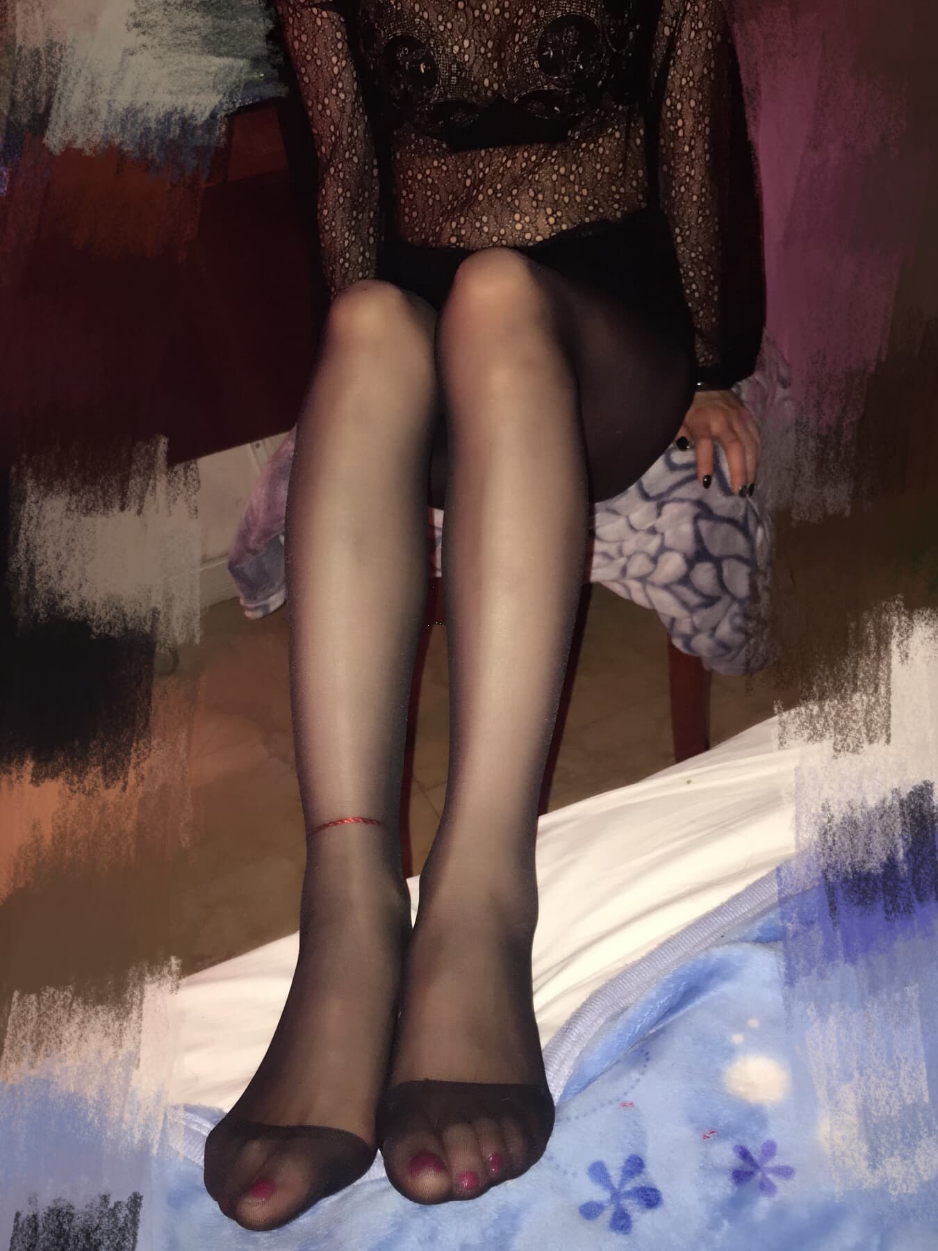 Moody portrait of legs in black sheer tights, one foot bare at the toe, spotlighting nylon sheen and sleek silhouette.